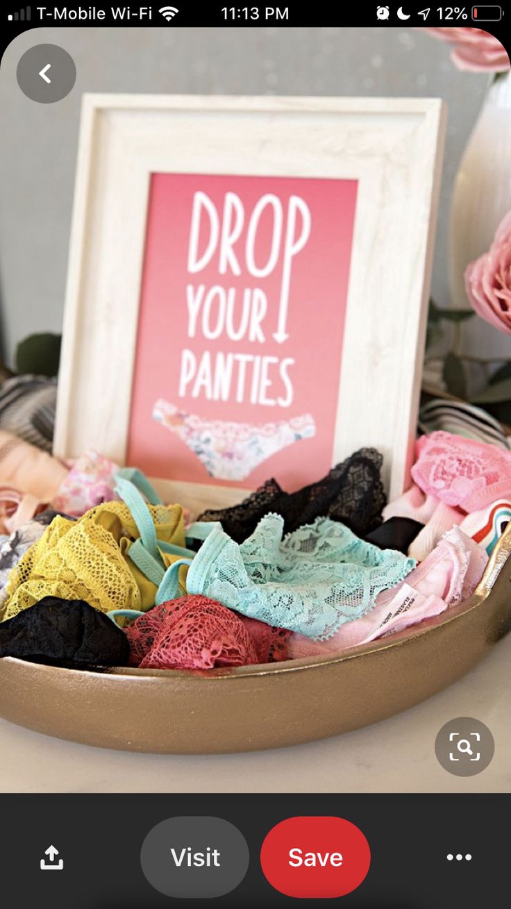 a basket filled with lots of clothes next to a pink sign that says drop your panties