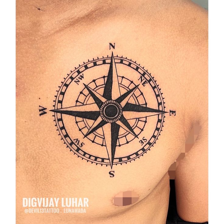 a man with a compass tattoo on his chest