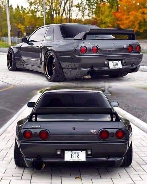 two cars parked side by side in front of each other on the street, one is black