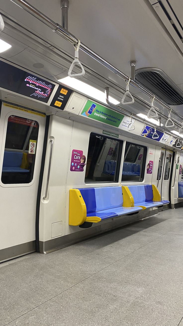 an empty subway car with blue and yellow seats