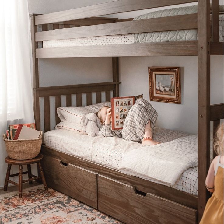 a little boy laying on top of a bunk bed