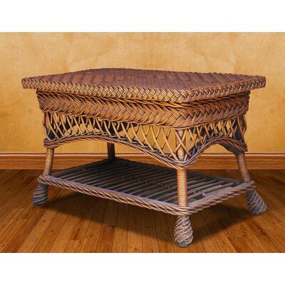 a wicker coffee table sitting on top of a wooden floor