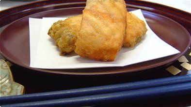 two fried food items on a plate with chopsticks