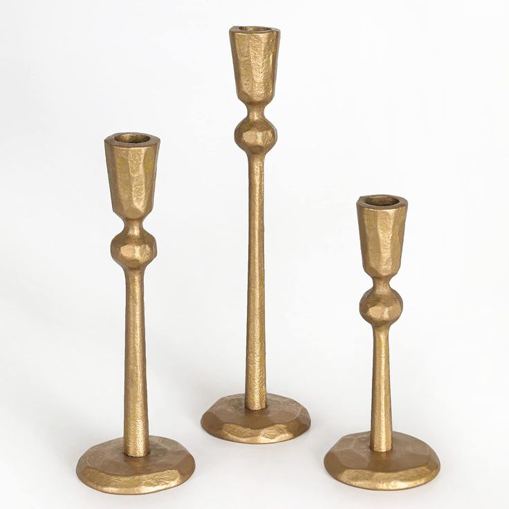 three brass candlesticks are standing next to each other