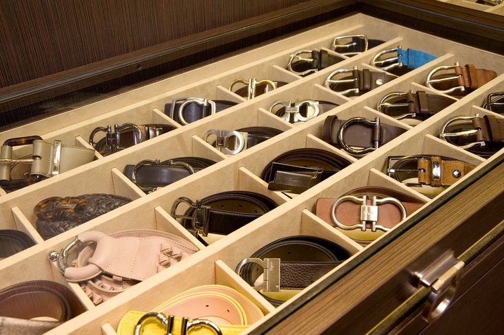 a drawer filled with lots of different types of belts and belt buckles in it