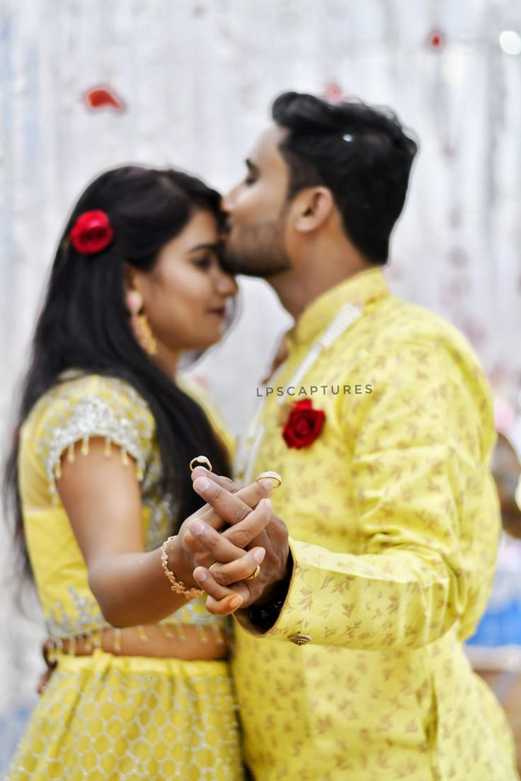 a man and woman dressed in yellow posing for the camera while holding each other's hands