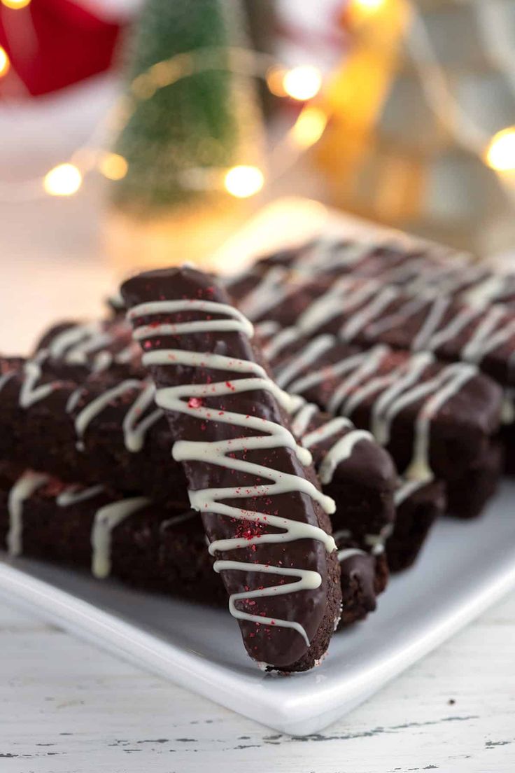 there are chocolate cookies with white icing on the plate