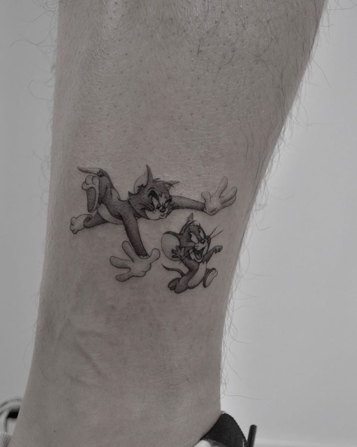 a cat and dog tattoo on the ankle