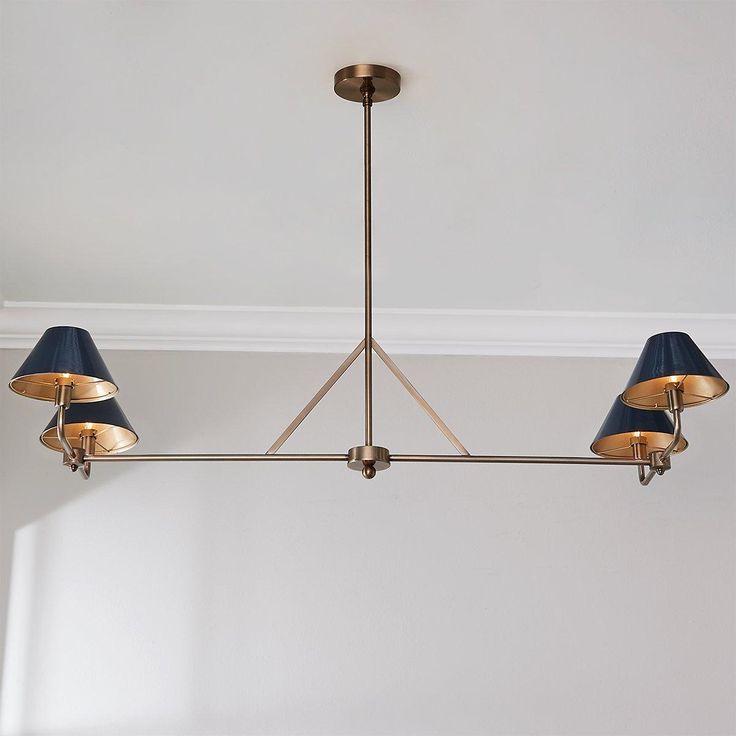 a chandelier with three blue lamps hanging from it's sides in a room