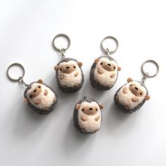 four keychains made to look like hedgehogs with faces painted on them