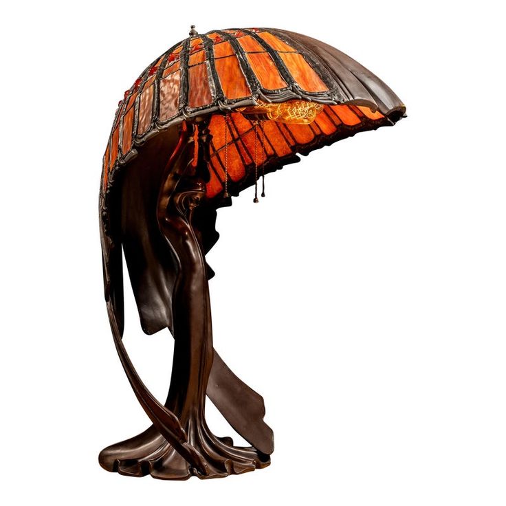 a lamp that is sitting on top of a wooden stand with a glass shade over it