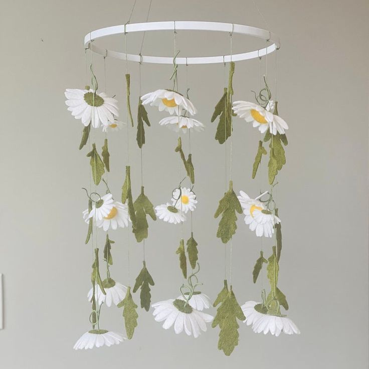 a wind chime with white flowers and green leaves