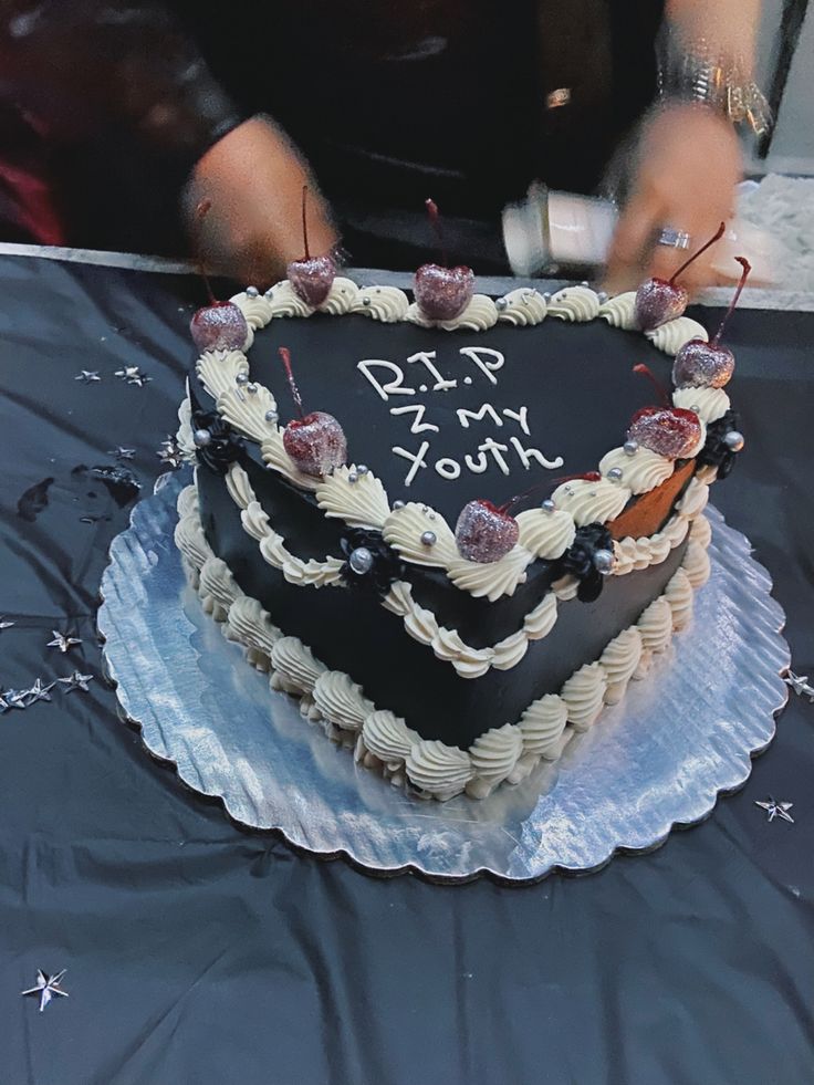 a heart shaped cake with writing on the top is being held up by someone's hands