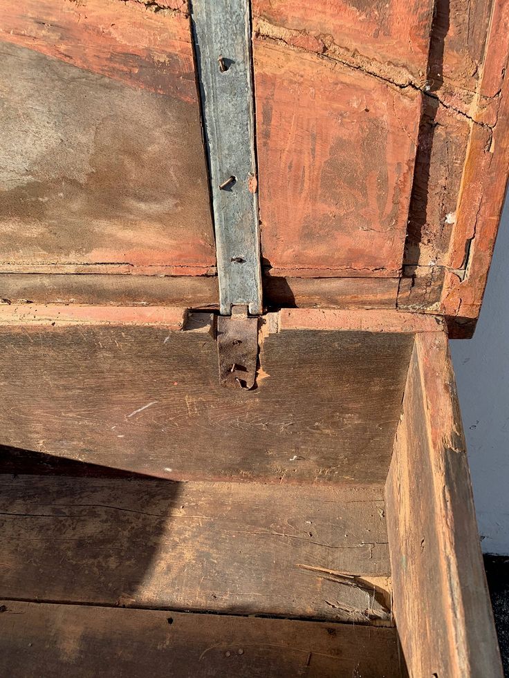 an old wooden box with metal latch on it