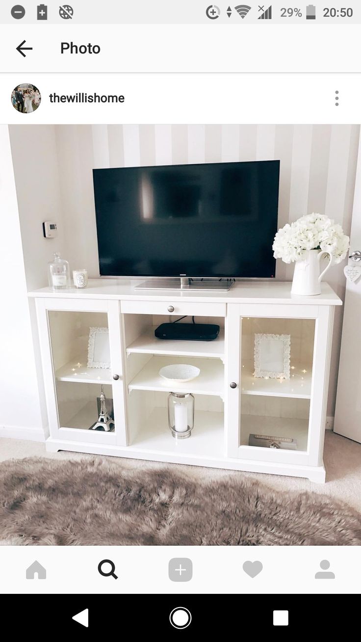 a flat screen tv sitting on top of a white entertainment center