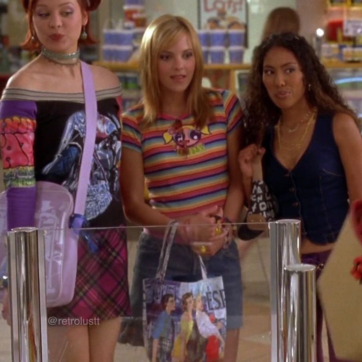 three women standing in a store holding shopping bags