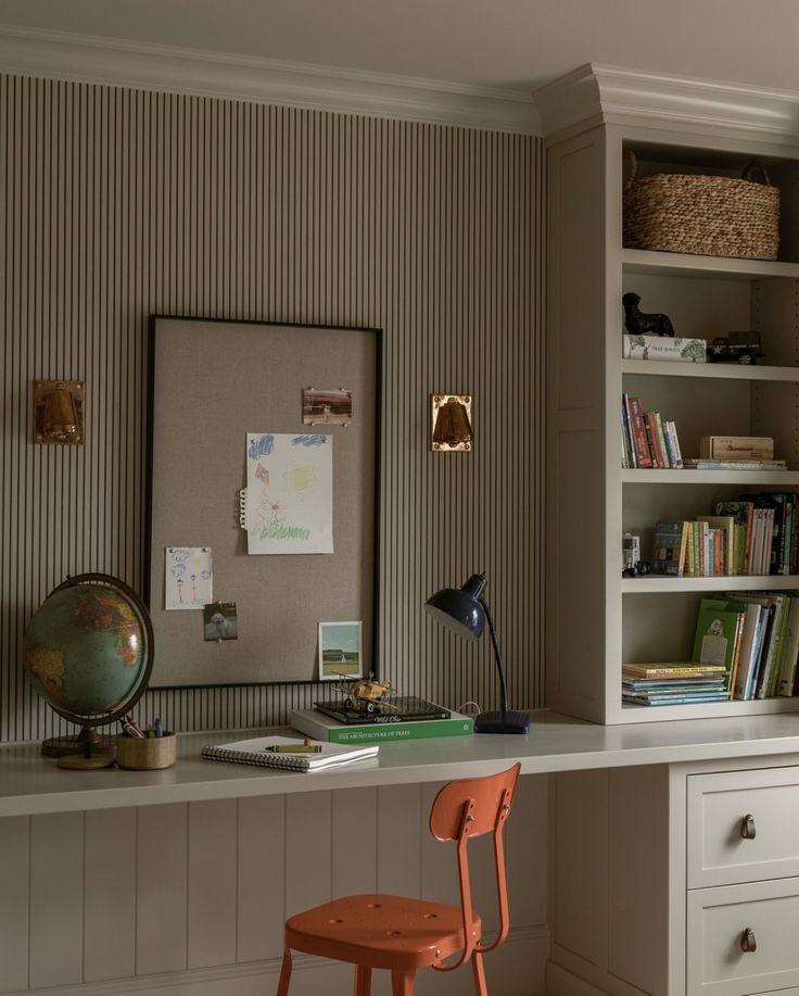 a desk with a chair and bookshelf in the corner, next to a book shelf