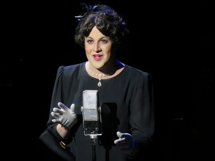 a woman wearing gloves and holding a microphone