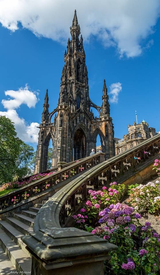 the stairs lead up to an ornate building with flowers growing on it's sides