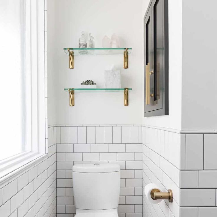 a white toilet sitting in a bathroom next to two shelves filled with soap and toothpaste