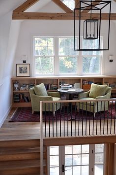 a living room filled with furniture next to a wooden floor covered in lots of windows