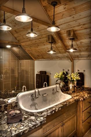 a bathroom with a large white tub sitting under three light fixture lights on the ceiling