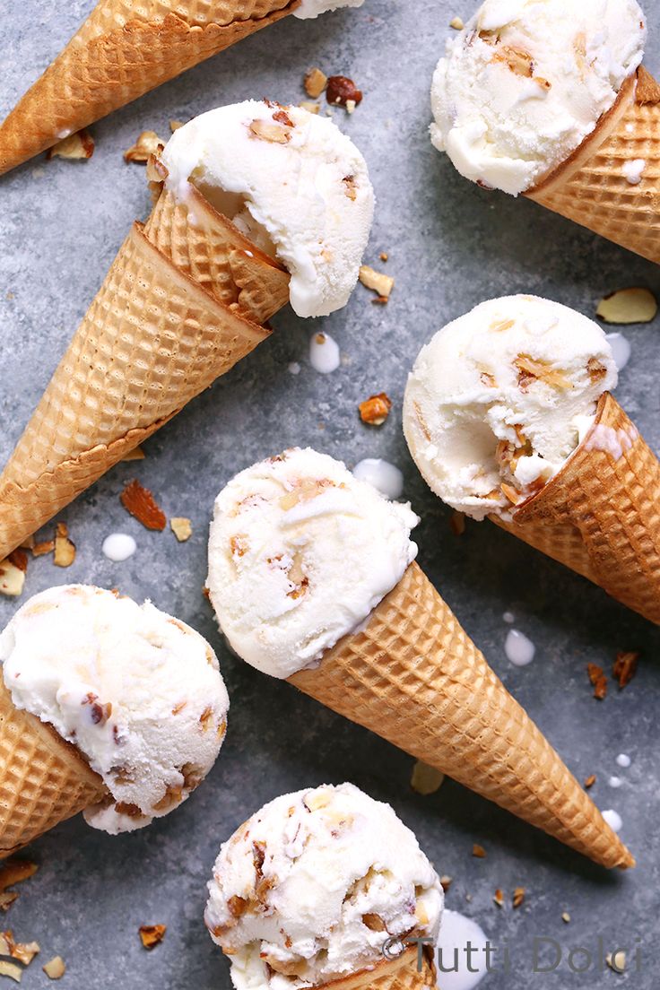 four ice cream cones with pecans scattered around them