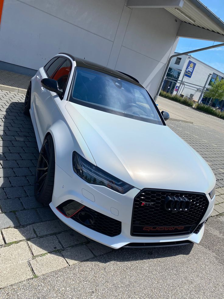 a white car parked in front of a building