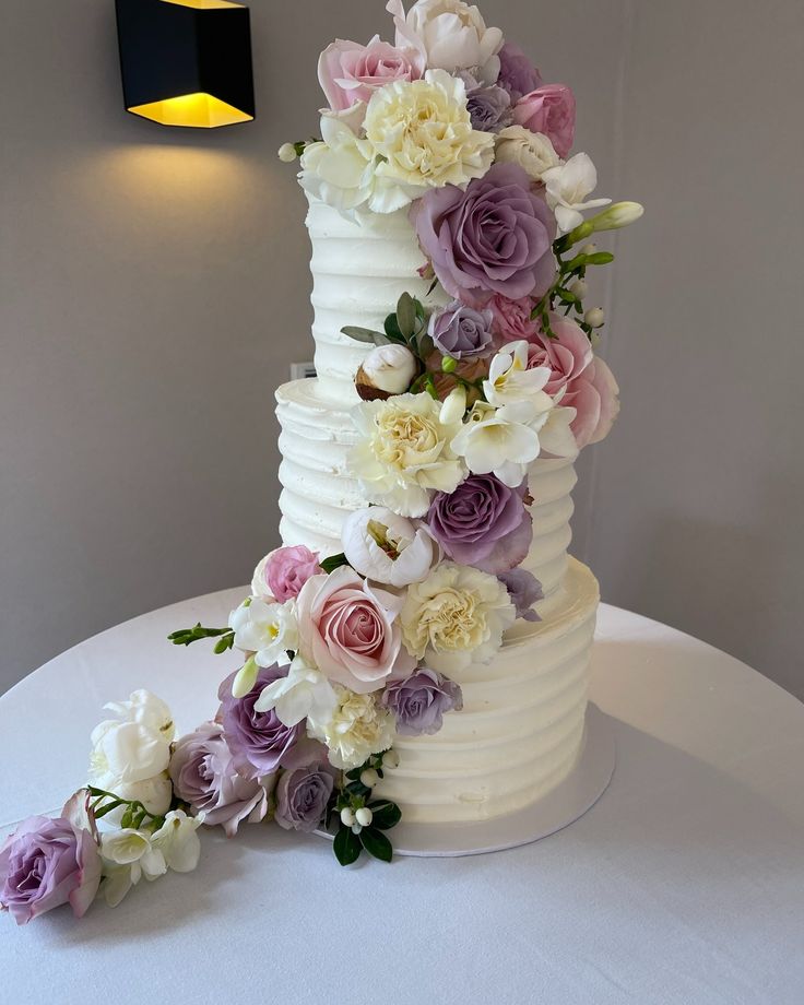 a wedding cake decorated with flowers on a table