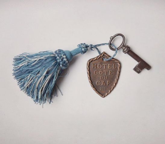 a keychain with a tassel hanging from it's side and the words hotel du cap written on it