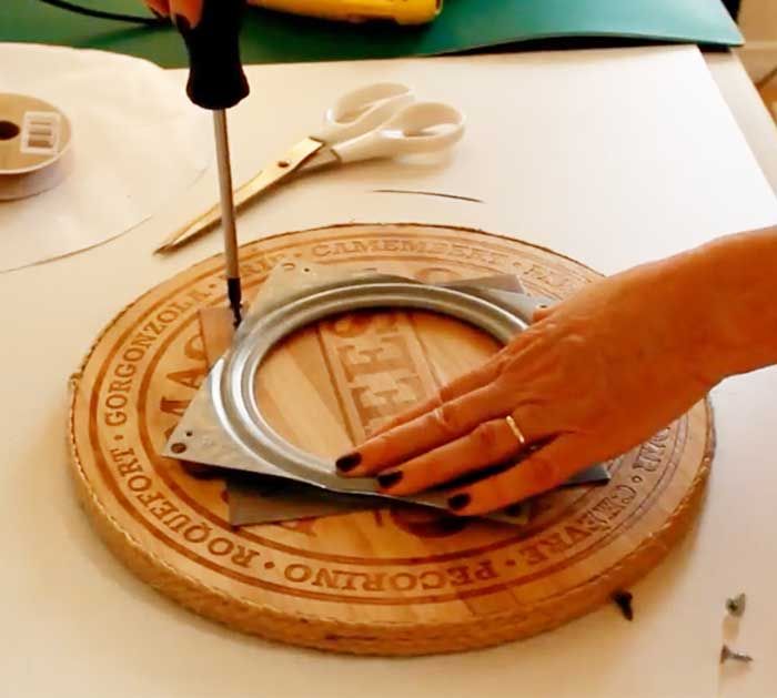 a person using a pair of scissors to cut into a piece of wood on top of a table