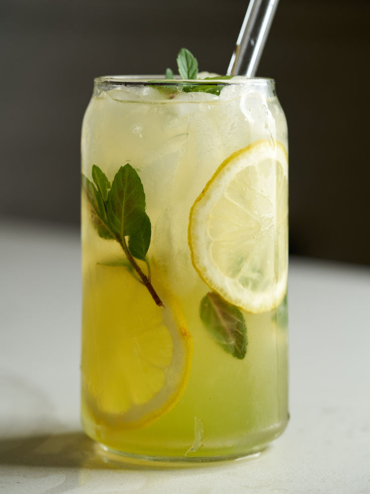 Glass on a counter containing light yellow lemonade, ice and sprigs of mint. Lemonade Serving Ideas, Fancy Lemonade Drink Recipes, Fun Drinks Nonalcoholic, Mint Lemonade Aesthetic, Asian Lemonade, Lemonade Green Tea, Lemon And Mint Drink, Lemon Mint Drink, Lemonade Aesthetic