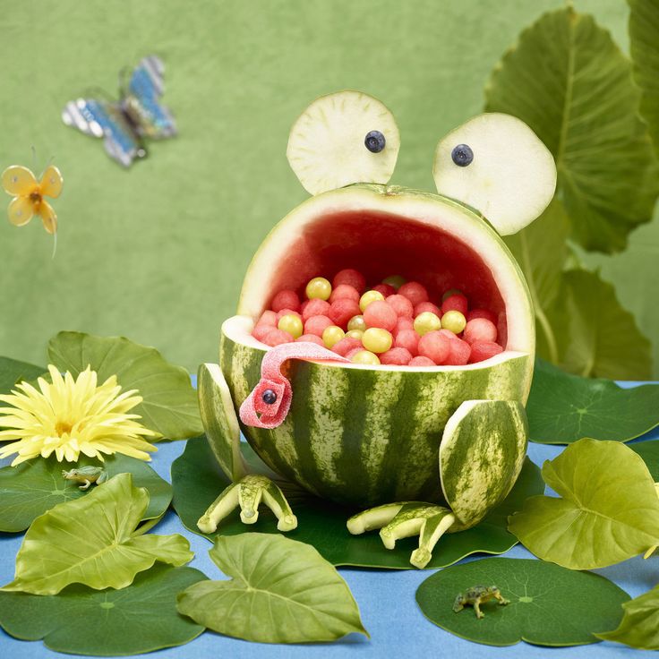 a watermelon shaped like a frog with balls in it's mouth and eyes