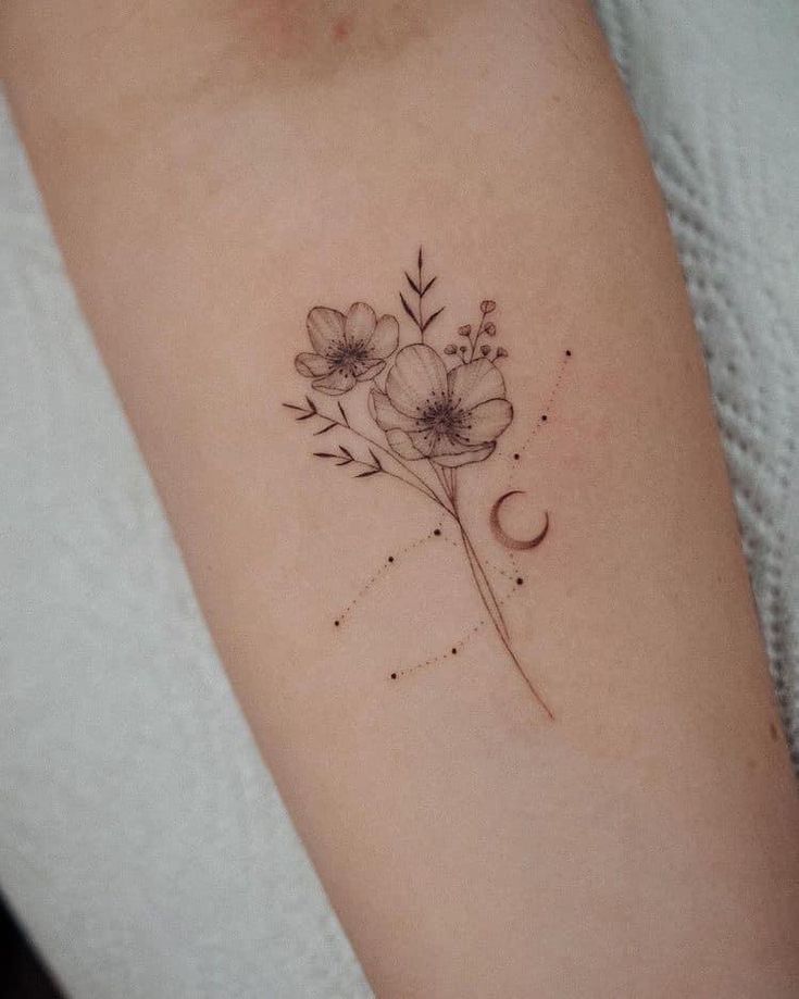 a small flower tattoo on the right arm and shoulder, with an arrow in the middle