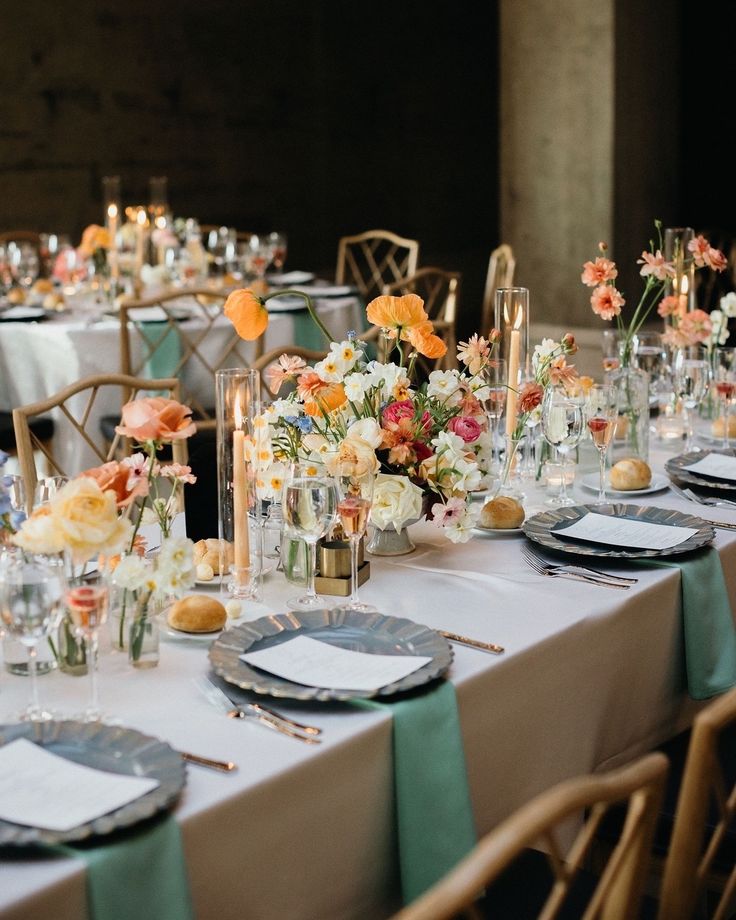 a long table is set with flowers and candles for an elegant wedding reception or special event