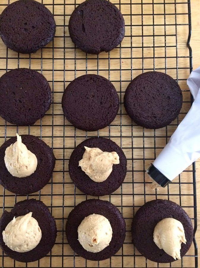 chocolate cookies with cream frosting on a cooling rack