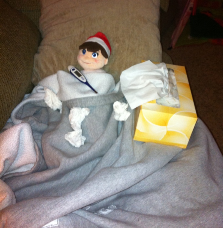 an elf is laying on the couch with his stuff in front of him and wrapped in a blanket