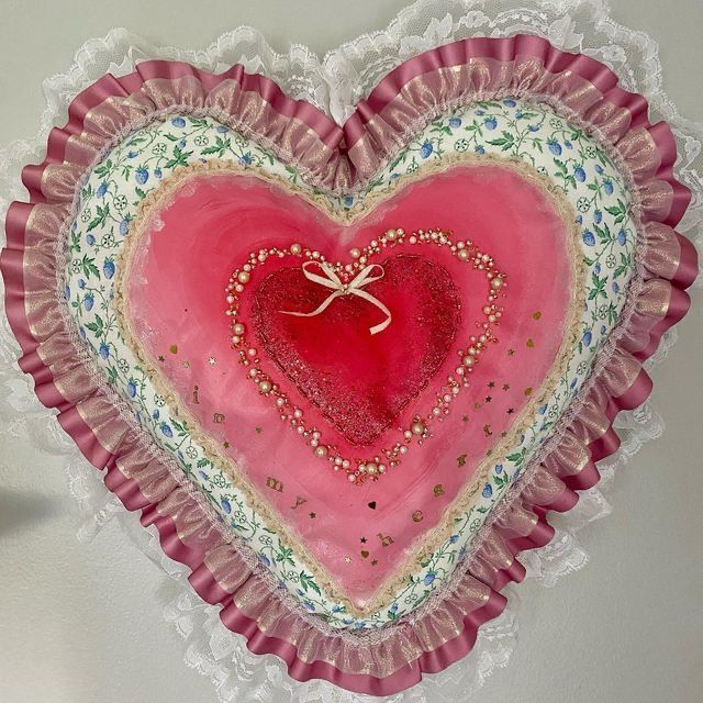 a pink heart shaped plate hanging on the wall