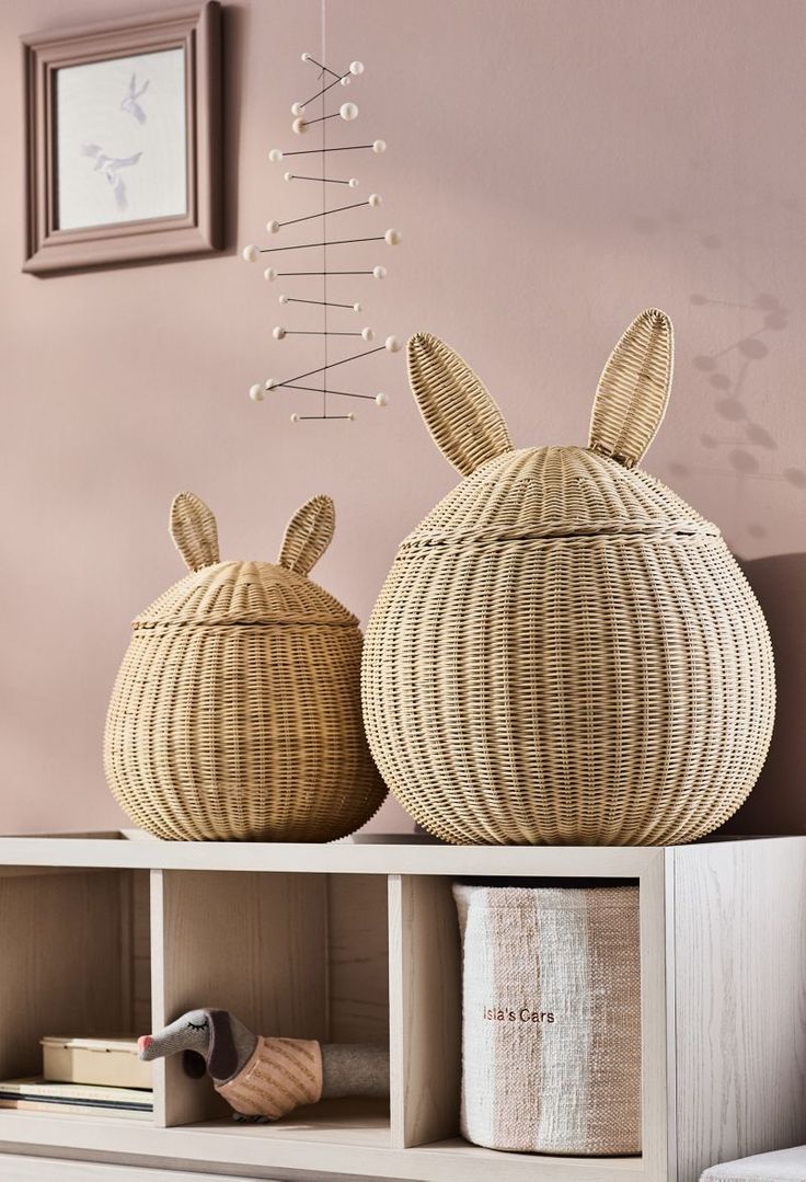 two baskets sitting on top of a wooden shelf