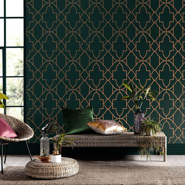 a living room with green wallpaper and two wicker chairs in front of the window