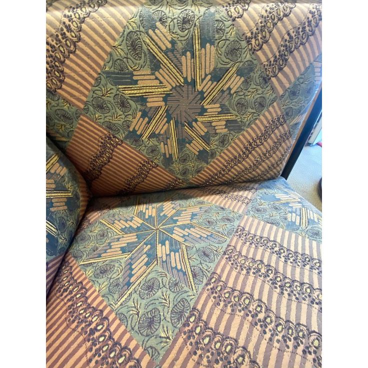 an upholstered chair with blue and gold designs on it's seat cushion