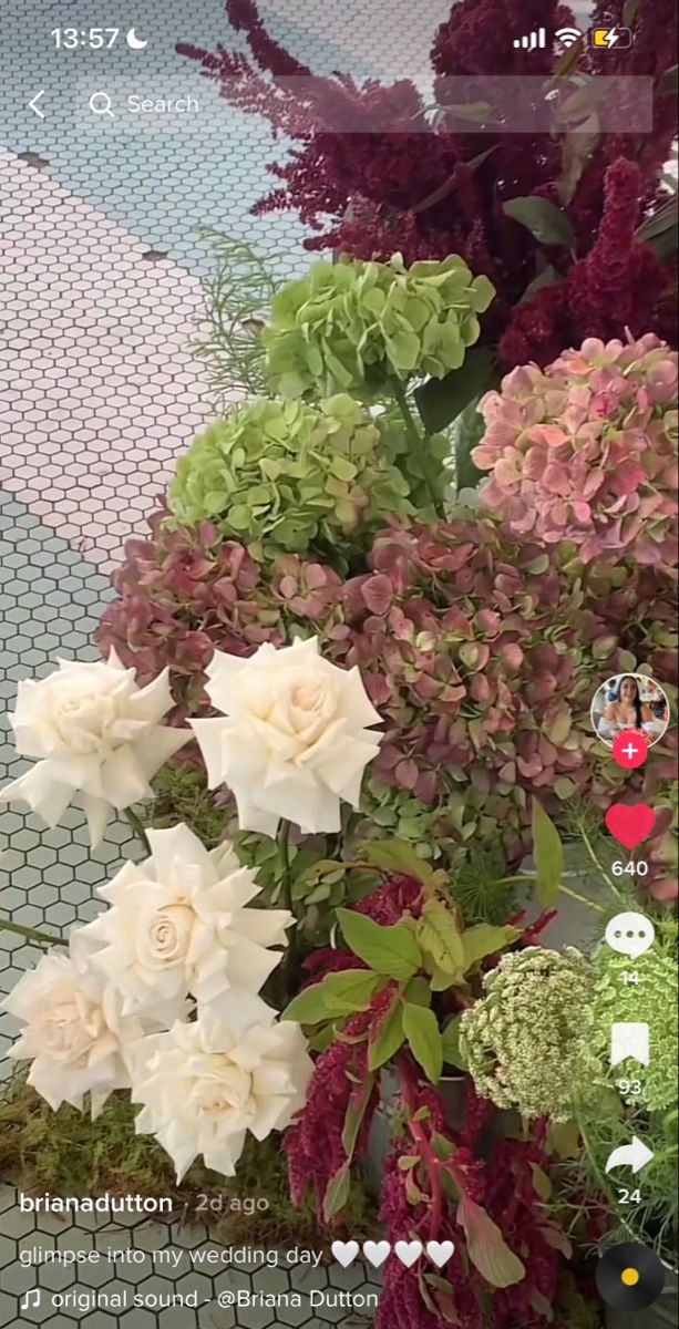 flowers are arranged in a vase on the phone screen, with texting below them