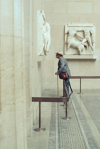 a man sitting on top of a bench in a museum