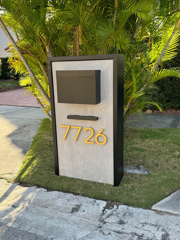 a mailbox with the number 726 on it in front of some palm trees