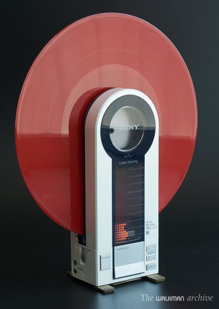 a record player sitting on top of a red disk shaped object in front of a black background