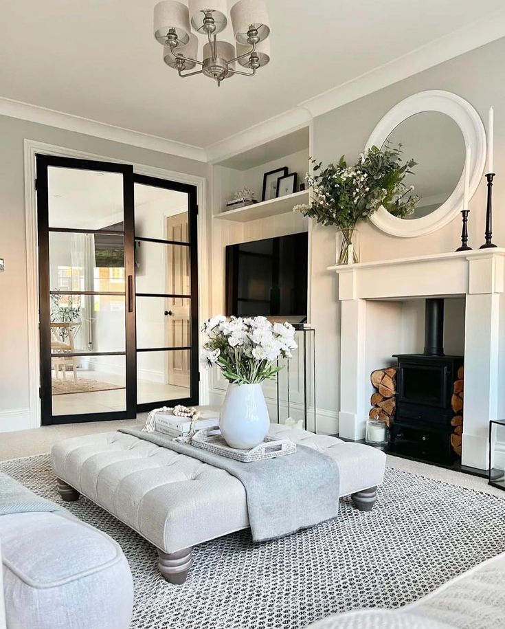 a living room filled with furniture and a fire place in front of a tv mounted on a wall