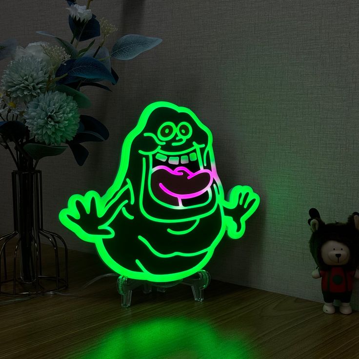 a neon green cartoon character sitting on top of a wooden table