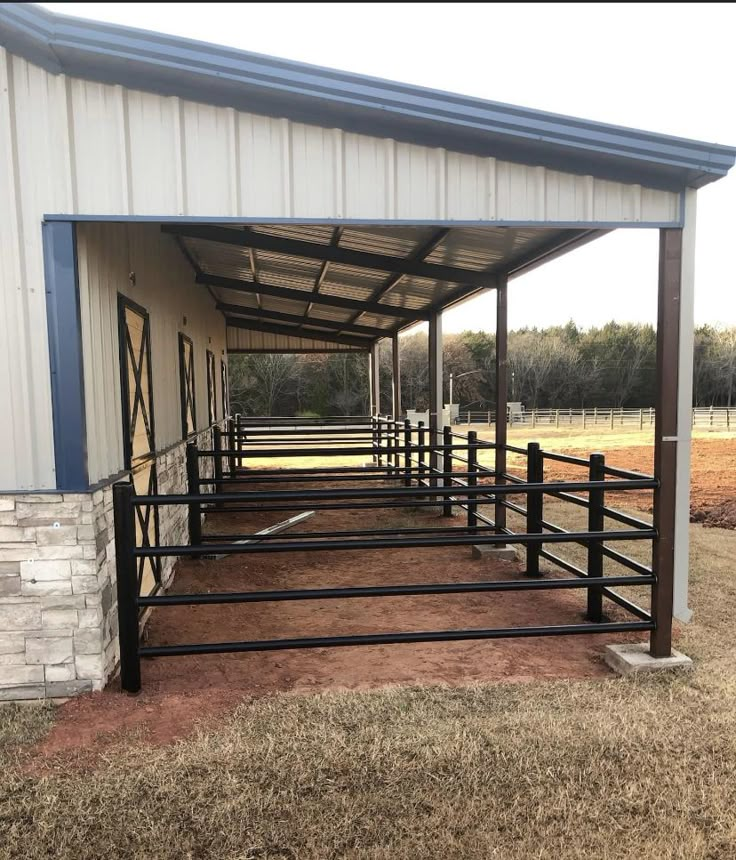 several horses are lined up in their stalls at the stables on an open day with no one around them