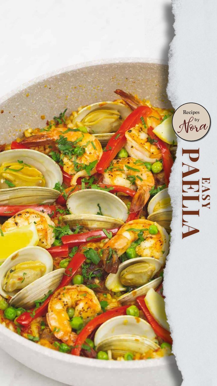 a pan filled with clams and vegetables on top of a white countertop next to a piece of paper