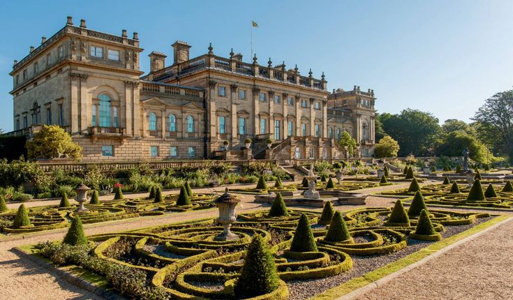 a large building with lots of hedges in front of it